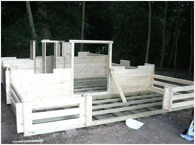 Log cabin kit walls being assembled on a base, Torwood Country Lodges