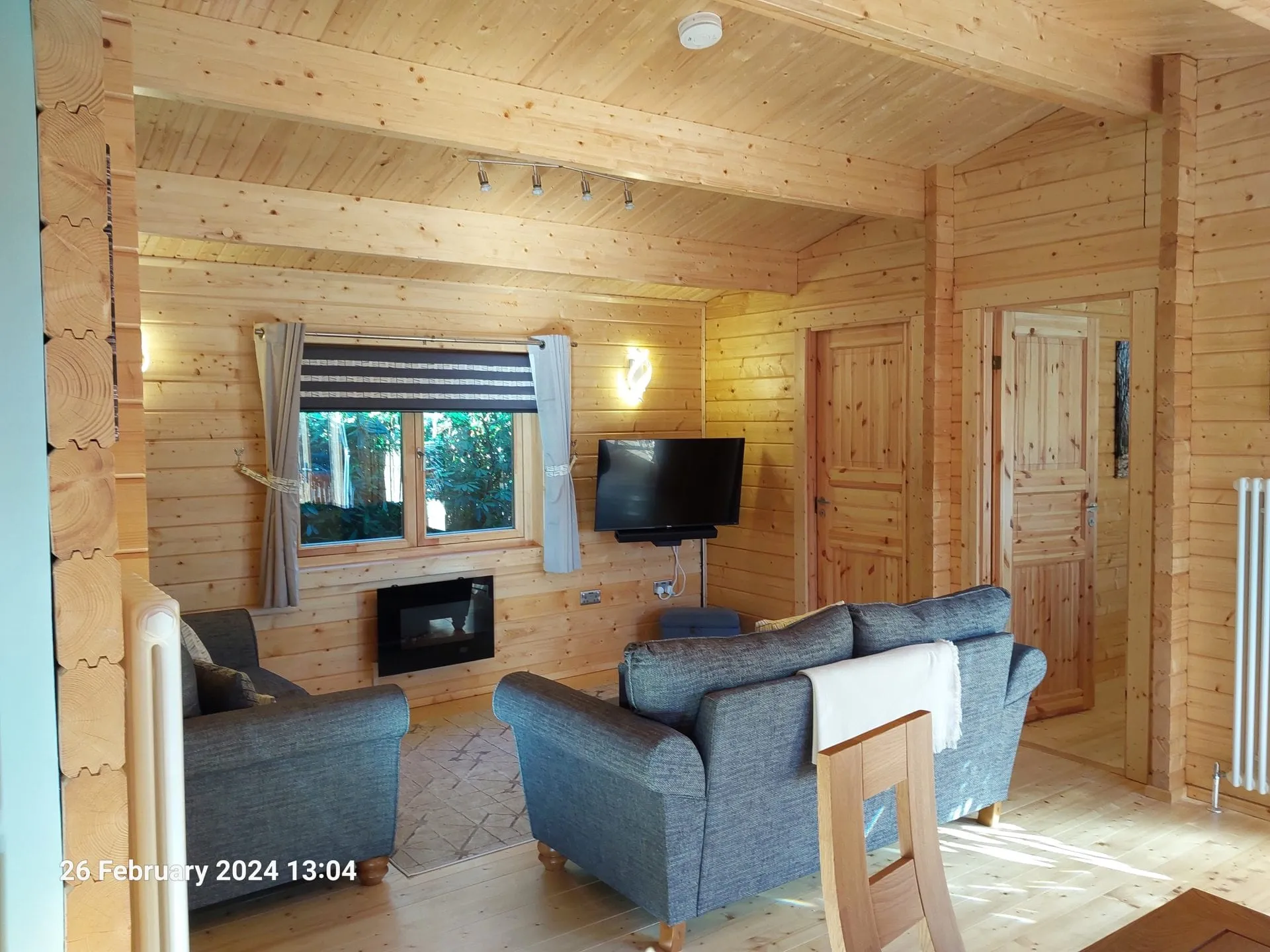 Living room with sofas and TV in Little Lodge, Torwood Country Lodges, Newton Stewart