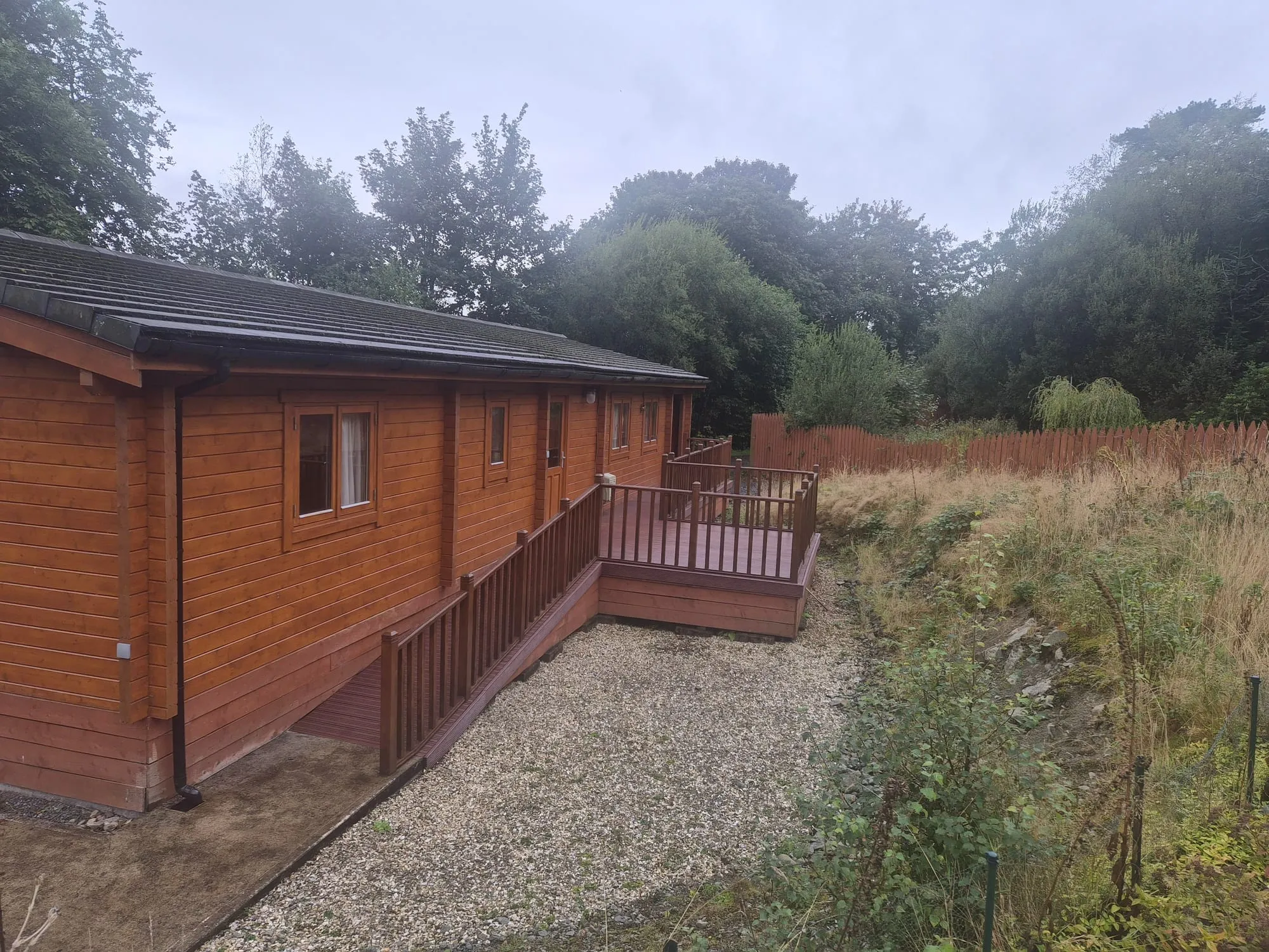 Timber lodge with decking and access ramp at Torwood Country Lodges